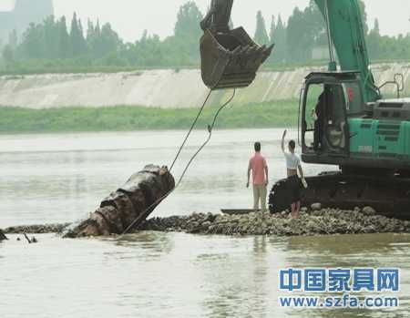 　6月22日，乌木被挖掘机从江中捞起。